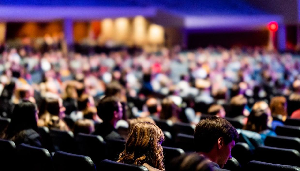 A large audience seated for a conference session