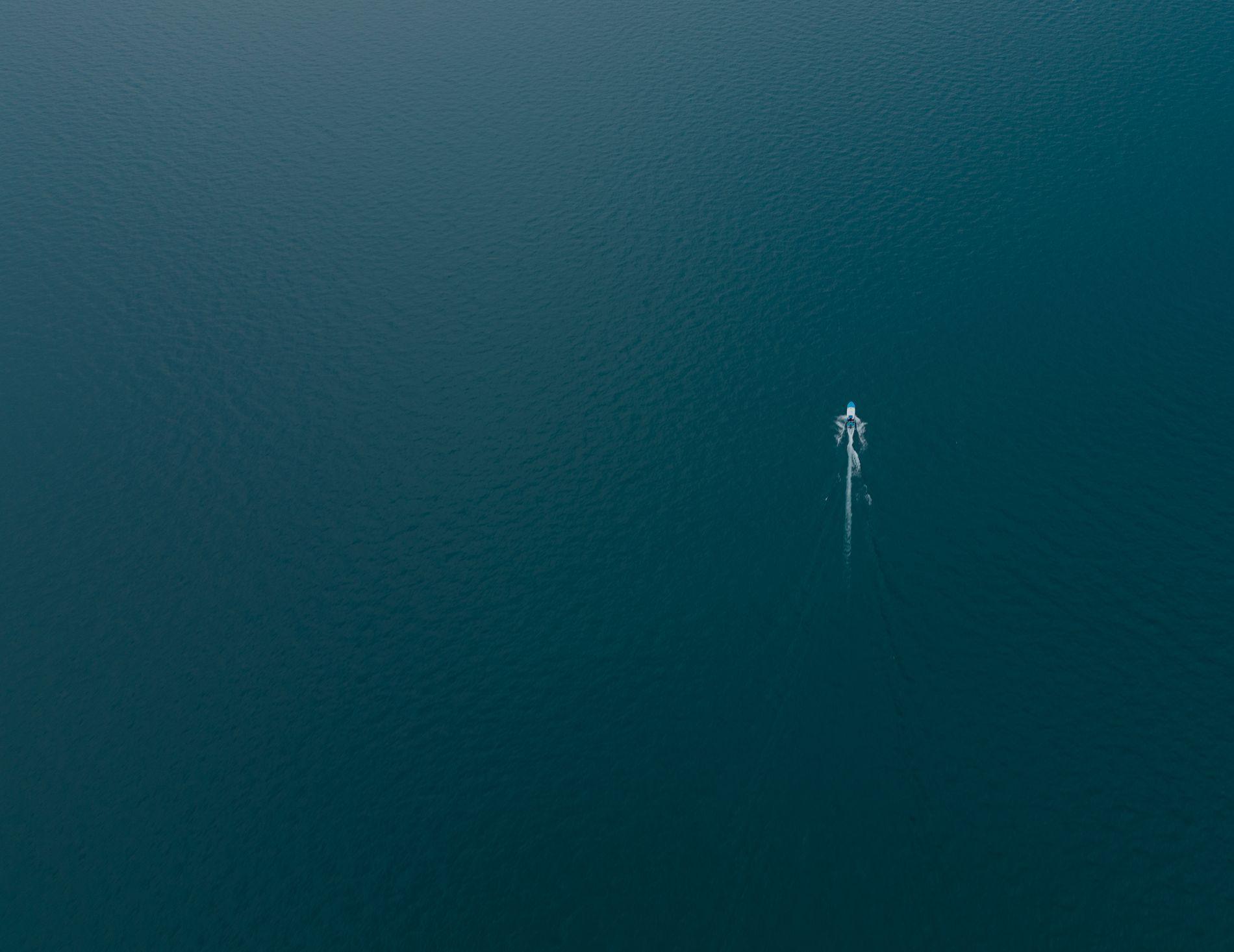 Aerial view of a vessel crossing deep blue open water
